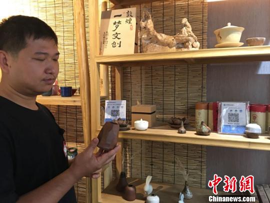 图为月牙泉小镇上的敦煌文化痴迷者叶金盛展示文创产品。 张婧 摄 图为月牙泉小镇上的敦煌文化痴迷者叶金盛展示文创产品。 张婧 摄