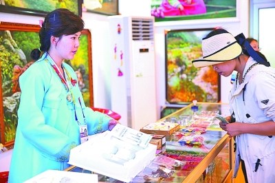 游客在朝鲜展馆购买特色产品。本报记者 郭俊锋/摄 游客在朝鲜展馆购买特色产品。本报记者 郭俊锋/摄